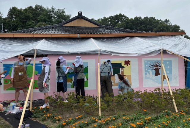 ▲ 이화여자대학교 배꽃나눔실천단 봉사단이 마을주민과 함께하는 벽화 그리기 봉사를 하고 있다. ⓒ괴산군