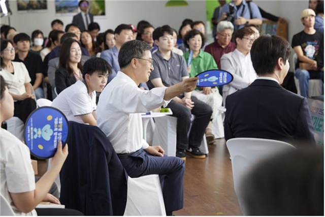 ▲ 김동연 도지사가 지난 6월 30일 시흥에코센터에서 진행된 '경기도 기후도민총회 출범식'에서 도민 참가자에게 부채질을 해주고 있다. ⓒ경기도 제공