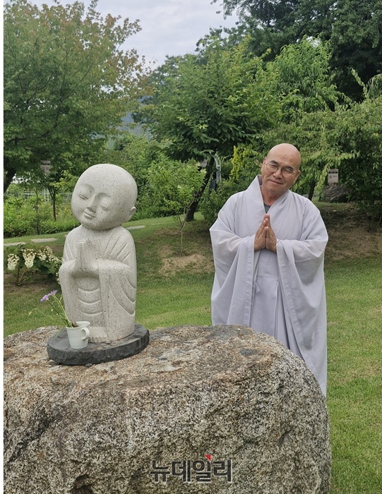 ▲ 정원을 산책하던 현진 스님이 바위에 설치한 동자상을 따라 합장하며 밝게 웃었다.ⓒ양승갑 기자
