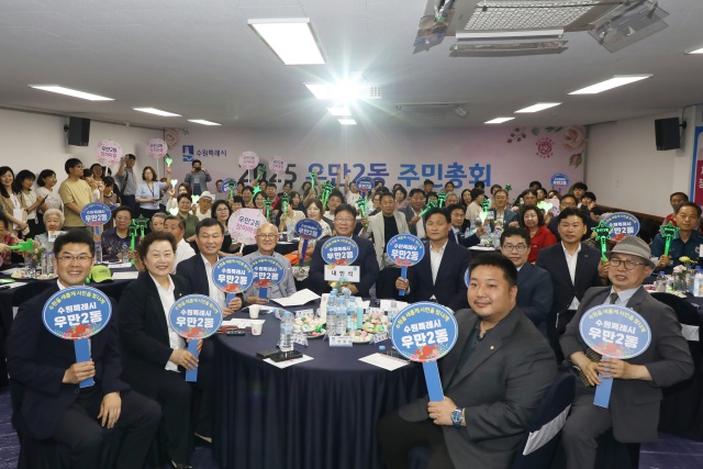 ▲ 우만2동 주민자치회의 2025년 주민총회에서 참가자들이 기념촬영을 하고 있다. ⓒ수원시 제공
