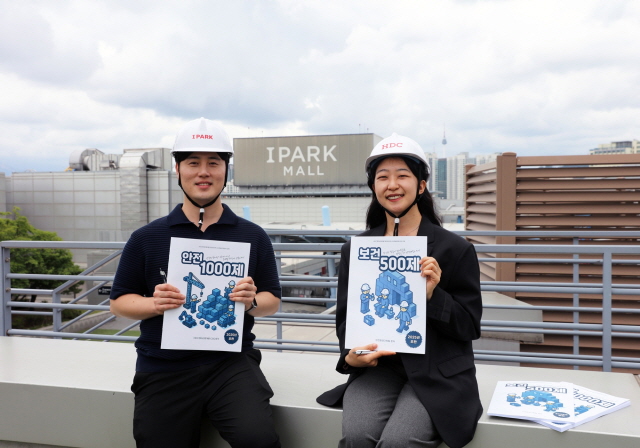 ▲ HDC현대산업개발 직원들이 현장에 배포될 안전·보건 문제집을 들어보이고 있다.ⓒHDC현산