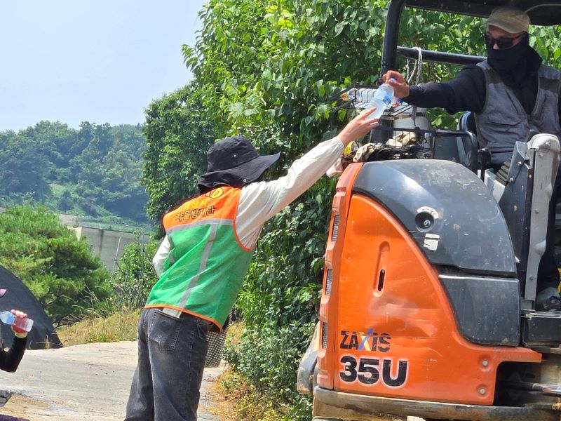 ▲ 아산시 자율방재단이 공사 현장을 찾아 얼음물을 나눠주고 있다.ⓒ아산시