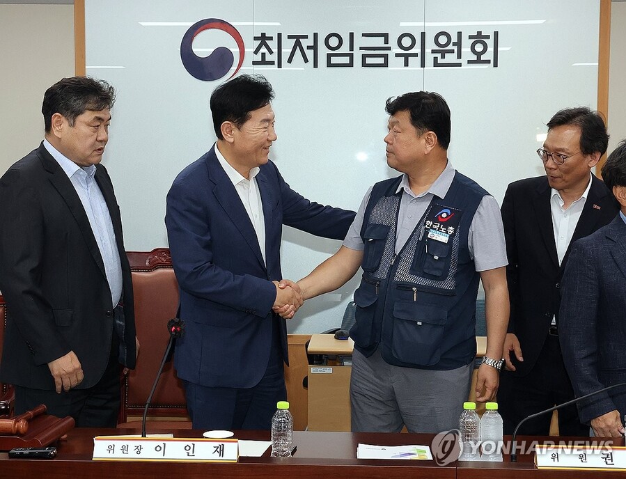 ▲ 최저임금위원회 사용자위원 운영위원인 류기정 한국경영자총협회 전무(왼쪽 두 번째)와 근로자위원 운영위원인 류기섭 한국노총 사무총장(오른쪽 두 번째)이 10일 정부세종청사에서 열린 제12차 전원회의에서 내년 최저임금을 시간당 1만320원으로 17년만에 합의로 결정한 뒤 악수하고 있다. 왼쪽은 이인재 위원장. ⓒ연합