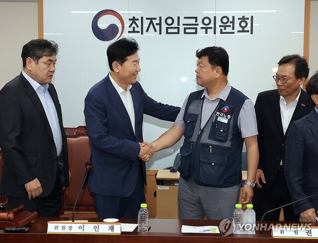 ▲ 최저임금위원회 사용자위원 운영위원인 류기정 한국경영자총협회 전무(왼쪽)와 근로자위원 운영위원인 류기섭 한국노총 사무총장이 10일 정부세종청사에서 열린 제12차 전원회의에서 내년 최저임금을 시간당 1만320원으로 17년 만에 합의로 결정한 뒤 악수하고 있다. 왼쪽은 이인재 위원장, 오른쪽은 이명로 중소기업중앙회 인력정책본부장. ⓒ연합뉴스