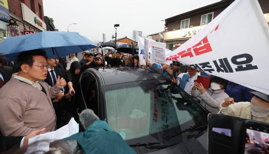 ▲ 이재명 대통령이 후보 시절 경북 고령군에서 대구에서 온 시민들의 지역주택조합 관련 하소연을 듣고 있다. ⓒ연합뉴스
