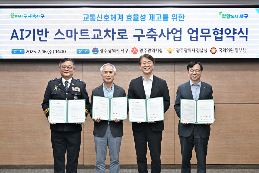 ▲ 김이강 광주 서구청장이 16일 서구청 이음홀에서 열린 'AI기반 스마트 교차로 구축사업 업무협약식'에서 협약서에 서명한 후 참석자들과 기념촬영을 하고 있다. ⓒ광주시 서구청 제공