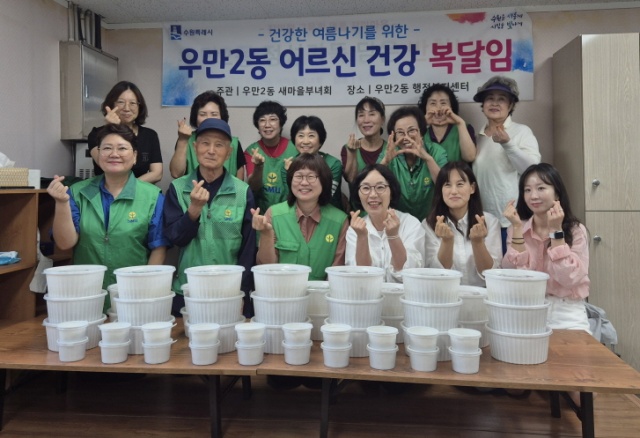 ▲ 수원 우만2동 새마을부녀회 회원들이 이웃들에게 전달한 삼계탕을 준비한 뒤 기념촬영을 하고 있다. ⓒ수원시 제공
