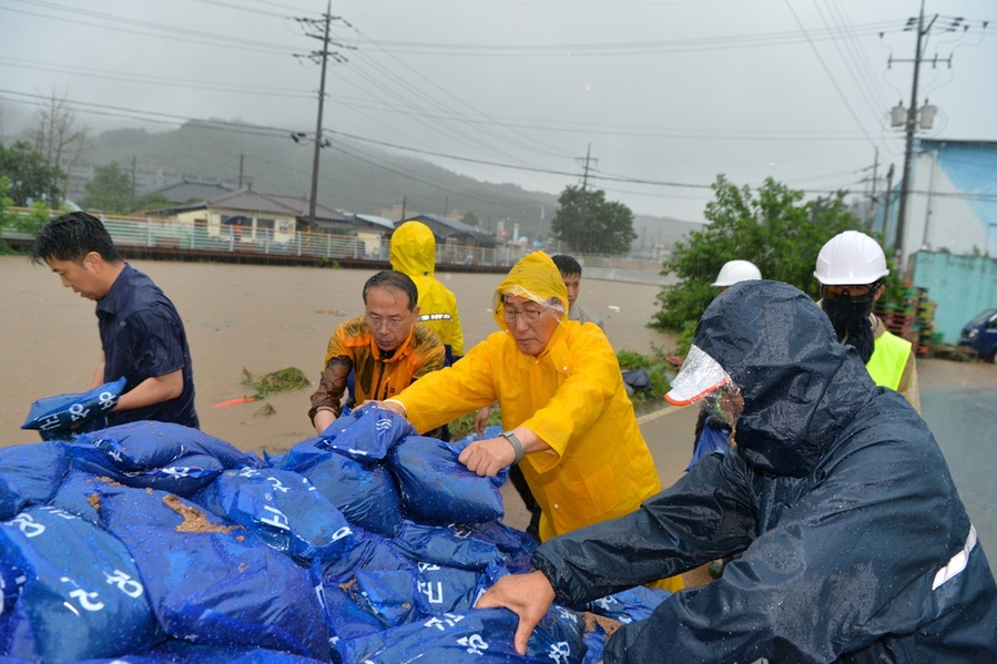 ▲ 이용록 홍성군수가 17일 새벽 홍성천 등의 하천 수위가 높아지자 군청 직원과 주민들과 함께 하천 범람을 막기 위해 흙을 넣은 비닐 포대를 하천변에 높이 쌓고 있다.ⓒ홍성군