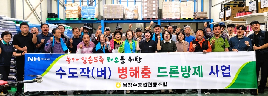 ▲ 남청주농협 임직원과 조합원들이 벼 병해충 공동 항공방제에 앞서 관계자들과 기념촬영을 하고 있다. ⓒ충북농협