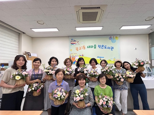 ▲ 광교1동 '힐링 꽃꽂이 교실' 참가자들이 손수 디자인 한 꽃바구니를 들고 기념촬영을 하고 있다. ⓒ수원시 제공
