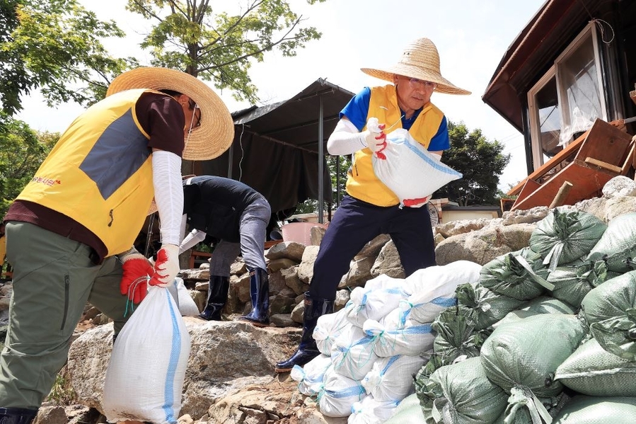 ▲ 23일 충남 서산시 수해 피해 마을에서 환경정비 활동 중인 이성해(오른쪽) 국가철도공단 이사장과 본사 직원봉사단 ⓒ국가철도공단