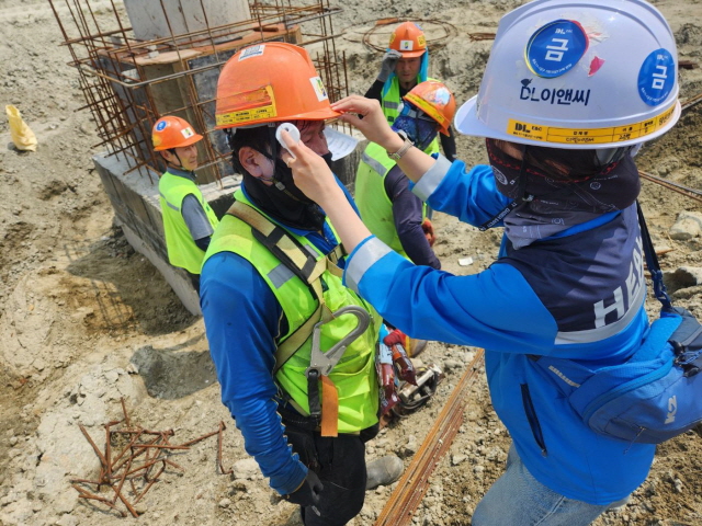 ▲ DL이앤씨 현장 안전보건관리자가 근로자 체온을 측정하고 건강상태를 확인하고 있다. ⓒDL이앤씨