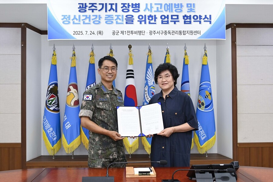 ▲ 김영주(대령) 기지방호전대장과 황춘옥 광주서구중독관리통합지원센터장이 업무협약서에 서명 후 기념촬영을 하고 있다.ⓒ제1전투비행단 제공