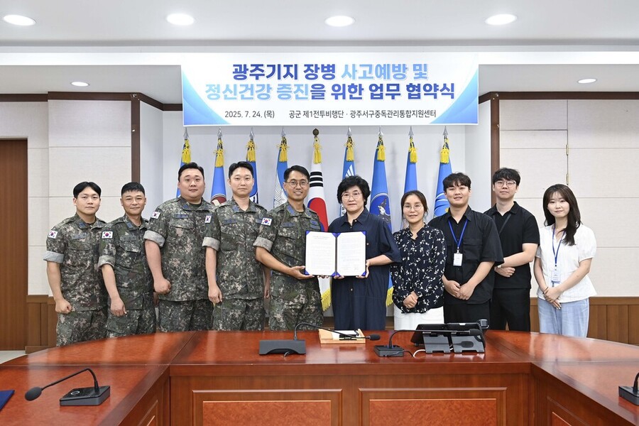 ▲ 김영주(대령) 기지방호전대장과 황춘옥 광주서구중독관리통합지원센터장이 업무협약서에 서명 후 단체 기념촬영을 하고 있다.ⓒ제1전투비행단 제공