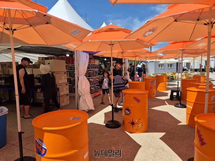 ▲ 브랜드컬러인 주황색을 사용해 파라솔과 드럼통을 꾸몄다.ⓒ조현우 기자