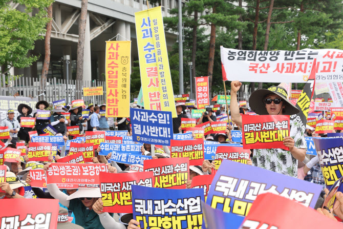 ▲ 지난달 31일 정부세종청사 산업통상자원부 앞에서 한국사과연합회, 한국과수농협연합회 관계자들이 미국산 사과수입 반대 국민대회를 열고 구호를 외치고 있다. ⓒ연합뉴스