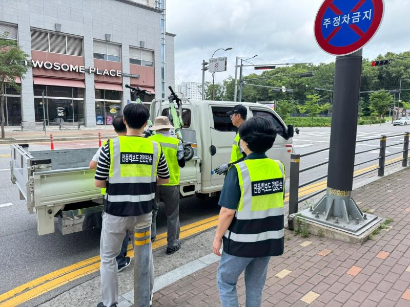 ▲ 천안시 공무원들이 개인형 이동장치(PM) 지정주차제 시행 이후 무단 방치된 PM을 견인하고 있다.ⓒ천안시