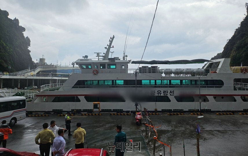 ▲ 높은 파고에 떠밀려 해안산책로에 충돌한 유람선이 자력 항해가 가능하자 도동항 활어회센터 인근서 승객 하선 뒤 정박하고 있다. ⓒ뉴데일리