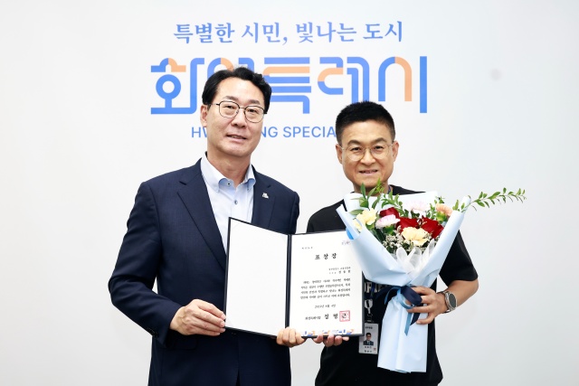 ▲ 정명근 화성특례시장(좌)과 정동헌 주무관(우)이 기념촬영을 하고 있다ⓒ화성시 제공