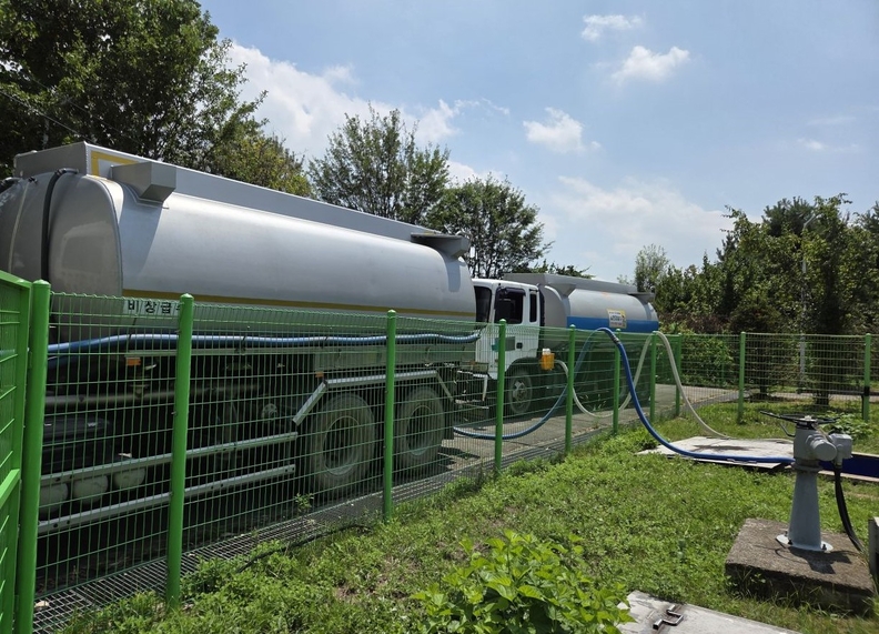 ▲ 5일 새벽 증평읍 사곡리 지하 송수관로에서 누수가 발생해 증평읍 전역 1만7620세대에 단수가 이어지고 있다. 증평군은 즉시 재난안전대책본부를 가동하고, 비상대응체계를 구축해 급수차 18대와 생수 8만 병을 공급 중이다. 증평군과 한국수자원공사 충주권관리단이 5일 오후 급수차를 동원해 증평배수지에 물을 차에 채우고 있다.ⓒ증평군