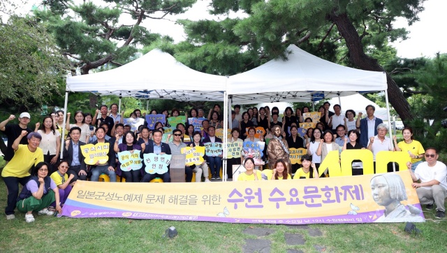 ▲ 6일 수원 올림픽공원에서 열린 제100차 수원수요문화제에서 이재식 수원시의회 의장을 비롯한 참석자들이 일본군 위안부 문제의 역사적 진실 규명을 촉구하며 기념촬영을 하고 있다. ⓒ수원시의회 제공