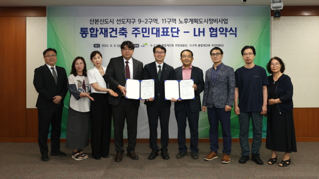 ▲ 군포산본 9-2구역 대표단장(왼쪽 4번째부터), 강오순 LH 지역균형본부장, 11구역 공동대표단장이 기념촬영을 하고 있다. ⓒLH