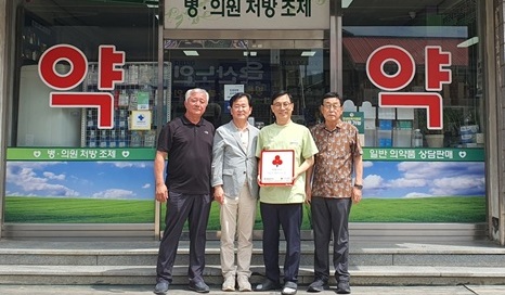 ▲ 부여군 은산면 지역사회보장협의체 위원들이 메디팜 중앙약국에 ‘착한가게’ 현판을 전달한 뒤 기념촬영을 하고 있다.ⓒ부여군