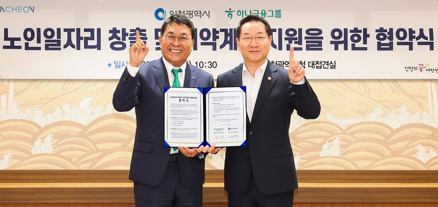 ▲ 하나금융그룹은 12일 인천시청에서 인천광역시와 지역사회 시니어 일자리 창출과 취약계층 지원을 위한 업무협약을 체결했다. 이날 협약식에 참석한 김진우 하나은행 중앙영업그룹 부행장(왼쪽)이 유정복 인천시장(오른쪽)과 함께 업무협약서를 들고 기념촬영을 하고 있다. ⓒ하나금융그룹