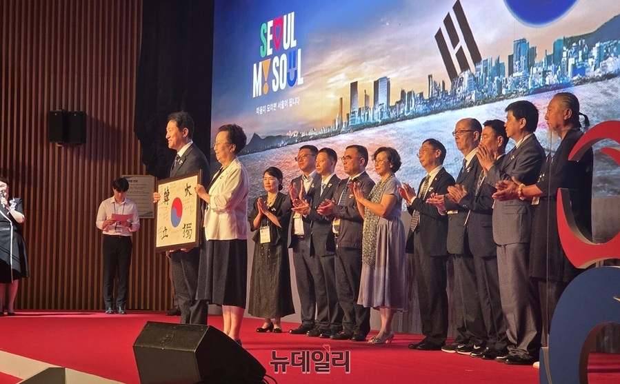 ▲ 오세훈 서울시장이 해외 거주 독립유공자 후손들과 함께 기념사진을 촬영하고 있다. 독립운동가 이달 선생의 장녀 이소심씨가 대표로 오 시장과 태극기를 들고 촬영을 했다.  ⓒ김승환 기자