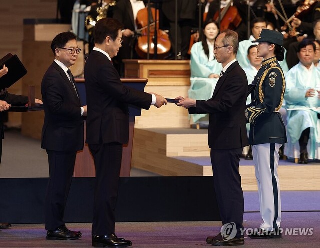 ▲ 이재명 대통령이 15일 서울 세종문화회관에서 열린 80주년 광복절 경축식에서 고(故) 이은숙 선생의 외손자 김종민 씨에게 건국훈장 애족장 훈장증을 전달하고 있다. ⓒ대통령실통신사진기자단