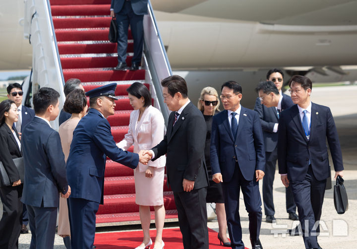 ▲ 한미 정상회담을 위해 미국을 방문한 이재명 대통령과 김혜경 여사가 24일(현지 시간) 워싱턴DC 앤드루스 공군기지에 도착해 조슈아 킴 대령과 악수하고 있다. ⓒ뉴시스