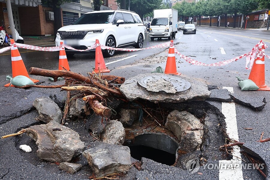 ▲ 서울 곳곳에 호우주의보가 내린 13일 서울 종로구 한 도로의 맨홀이 빗물 역류로 파손돼 있다. ⓒ연합뉴스