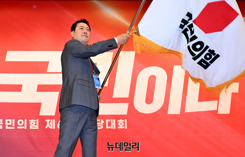 ▲ 국민의힘 장동혁 신임 당 대표가 26일 서울 여의도 국회도서관에서 열린 제6차 전당대회 결선에서 당 대표로 선출된 뒤 당기를 흔들고 있다. (사진=공동취재단)