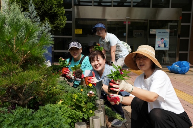 ▲ 광교1동 주민자치센터 3층 야외공간에서 주민들이 ‘광일이네 힐링테라스’ 조성을 위해 국화와 일일초를 심고 있다. ⓒ수원시 제공