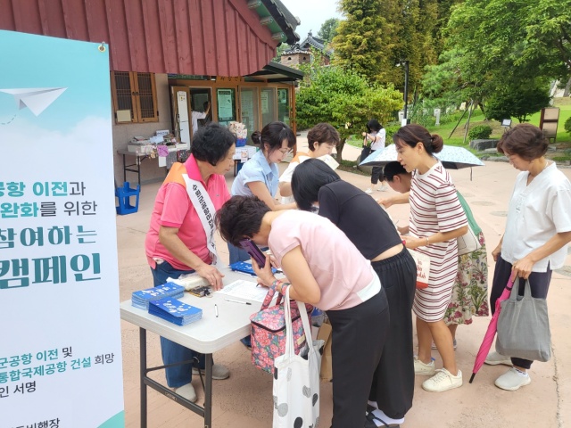 ▲ 수원 군 공항 이전 및 경기통합국제공항 추진 시민협의회 회원들이 대한불교조계종 봉녕사에서 군 공항 이전을 촉구하는 서명 캠페인을 하고 있다. ⓒ수원시 제공