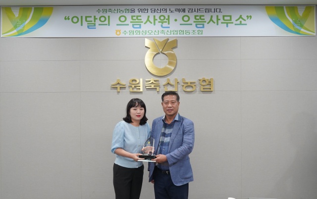 ▲ 장주익 수원축협 조합장(오른쪽)이 송민정 과장보에게 ‘이달의 으뜸사원패’를 전달한 뒤 기념촬영을 하고 있다. ⓒ수원축협 제공