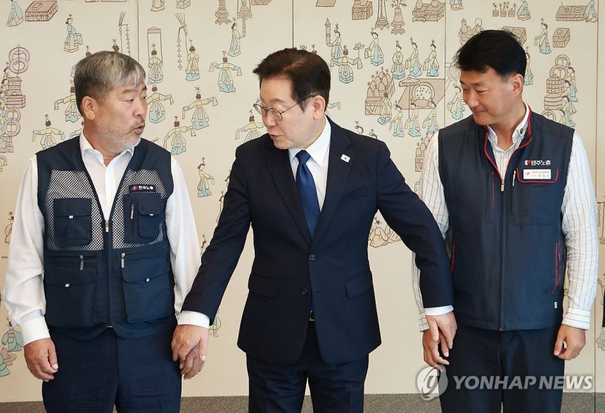 ▲ 이재명 대통령이 4일 서울 용산 대통령실 청사에서 열린 양대노총 위원장과의 오찬 간담회에 참석해 김동명 한국노총 위원장(왼쪽), 양경수 민주노총 위원장과 기념촬영을 하며 손을 잡고 있다.  ⓒ연합뉴스