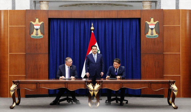 ▲ 패트릭 푸얀 토탈에너지스 CEO(왼쪽)와 류성안 현대건설 플랜트사업본부장이 지난 14일(현지시간 기준) 이라크 총리실에서 열린 계약 서명식에서 모하메드 시아 알수다니 이라크 총리가 지켜보는 가운데 계약을 체결하고 있다. ⓒ현대건설