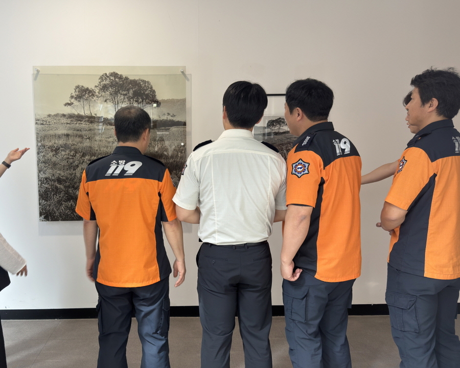 ▲ 김천소방서 소방관들이 전시작품을 감상하고 있다ⓒ