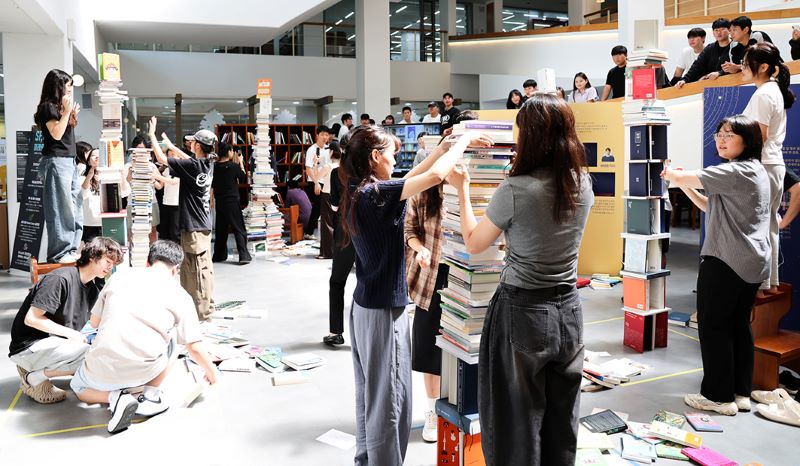 ▲ 2025 SCH도서전 ‘SF, 미래의 서재‘ 개막식에서 학생들이 기증도서를 활용해 책 탑쌓기 이벤트에 참여하고 있다.ⓒ순천향대