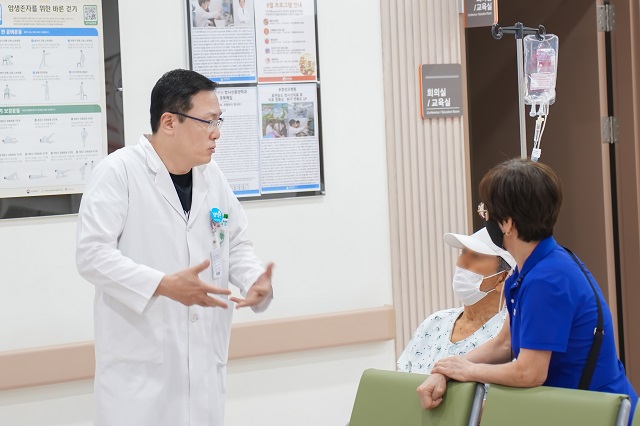 ▲ 포항성모병원 신경외과 김효창 과장이 치료전 환자와 이야기하고 있다.ⓒ포항성모병원