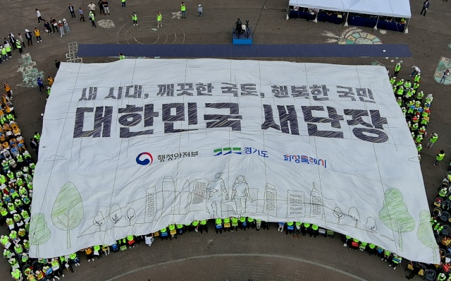 ▲ 대한민국 새단장 캠페인 행사 참석자들이 대형 현수막을 머리 위로 넘기며 ‘대한민국 새단장’ 결의 퍼포먼스를 하고 있다ⓒ화성시 제공