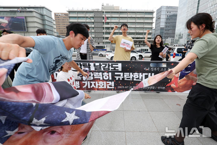 ▲ 한국대학생진보연합 대학생들이 지난 7월 31일 오후 서울 종로구 광화문광장에서 열린 한미 관세 협상 규탄 기자회견을 마친 뒤 미국 도널드 트럼프 미국 대통령이 그려진 현수막을 찢는 상징의식을 하고 있다. ⓒ뉴시스