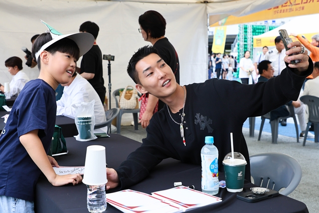 ▲ 한국 육상 높이뛰기 간판 우상혁이 시민과 사진촬영을 하고 있다. ⓒ용인시 제공