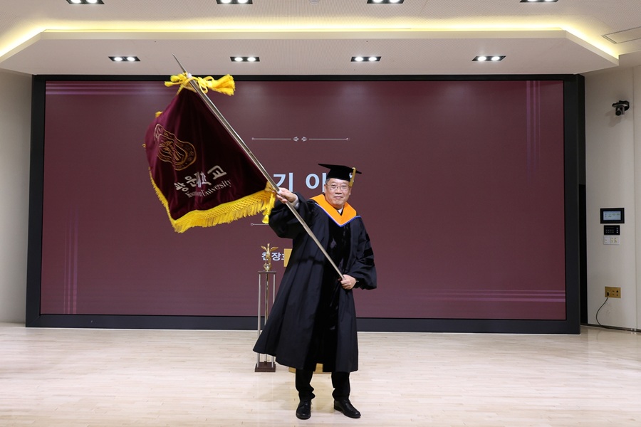 ▲ 광운대 제13대 윤도영 총장이 전임총장에게 이어받은 교기를 힘차게 흔들고 있다.ⓒ광운대