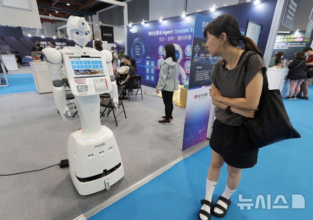 ▲ 대만 타이베이에서 열린 'AI 웨이브쇼'에서 한 여성이 AI 기술을 활용한 안내 로봇을 바라보고 있다. 250801 AP/뉴시스. ⓒ뉴시스