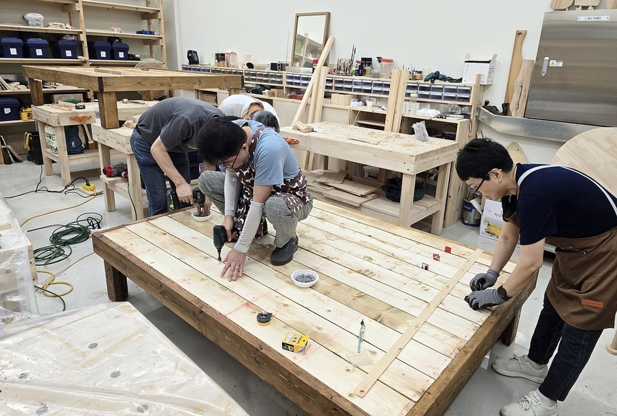 ▲ 인테리어디자인과 성인학습자 과정 학생들과 평생교육원 가구반 회원들이 들마루를 제작하고 있다.ⓒ영남이공대