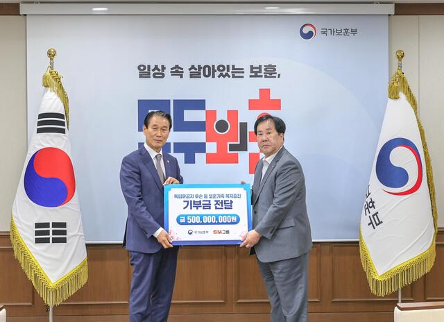 ▲ SM그룹 우오현 회장(오른쪽)이 13일 오전 정부세종청사에서 열린 국가보훈부의 전 국민 보훈 기부 프로젝트 ‘모두의 보훈 드림’ 후원금 전달식에서 권오을 장관과 기념촬영을 하고 있다. ⓒSM그룹