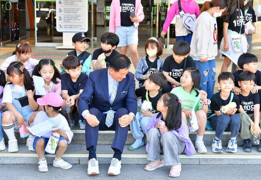 ▲ 김한종 장성군수가 지난해 봄 군청사 앞에서 장성중앙초등학교 학생들과 이야기를 나누고 있다.ⓒ장성군 제공