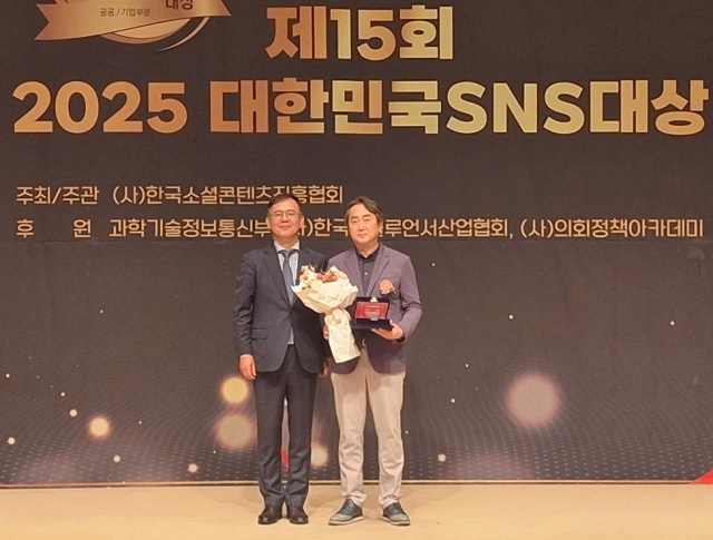 ▲ 김영식 경기관광공사 홍보마케팅 팀장(오른쪽)이 ‘2025 대한민국 SNS 대상’ 시상식에서 김민섭 ㈔한국소셜콘텐츠진흥협회 부회장에게 공공기관 공사부문 최우수상을 받은 뒤 기념촬영을 하고 있다. ⓒ경기관광공사 제공